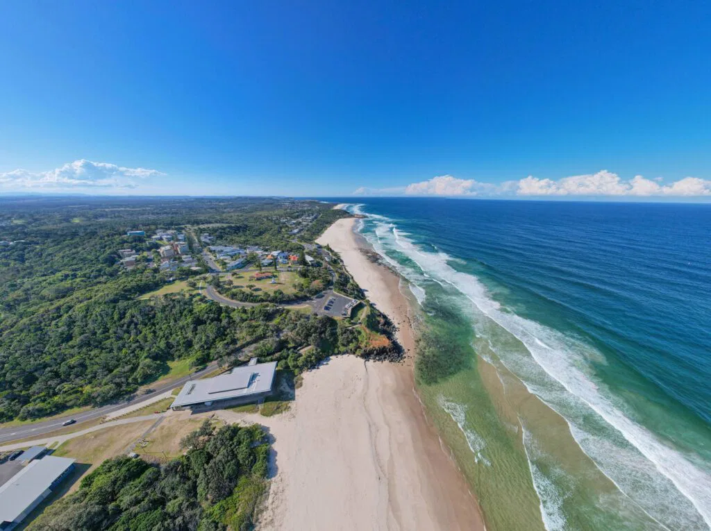 aerial view of a long coastal beach and headland